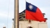 FILE - Two soldiers lower the national flag during the daily flag ceremony on Liberty Square of the Chiang Kai-shek Memorial Hall in Taipei, Taiwan, July 30, 2022. 