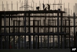 រូបឯកសារ៖ កម្មករ​សំណង់​កំពុង​ធ្វើការ​នៅ​ការដ្ឋាន​សំណង់​មួយ​ នៅជាយ​រាជធានីភ្នំពេញ កាលពីថ្ងៃទី២៦ ខែមករា ឆ្នាំ២០២១។