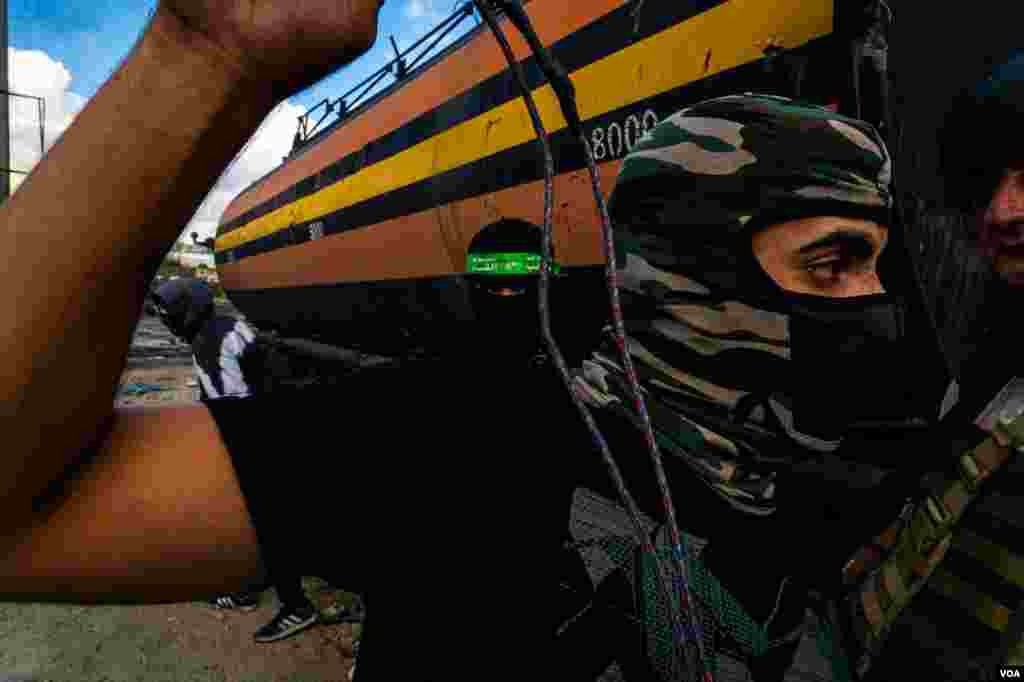 Young Palestinians prepare to attack Israeli soldiers with rocks during a protest on the outskirts of Ramallah, Oct. 20, 2023. (Yan Boechat/VOA)