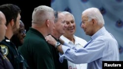 U.S. President Joe Biden speaks with a man as he visits Suwannee Pineview Elementary School during his tour of Hurricane Idalia storm destruction in Live Oak, Florida, Sept. 2, 2023.