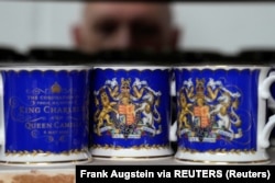 Seorang pekerja memeriksa kualitas barang pecah belah resmi di sebuah tembikar di toko Stoke-on-Trent, Inggris, 13 April 2023. (Foto: Frank Augstein via REUTERS)