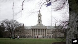FILE - Students gather outside Old Main on the Penn State University main campus in State College, Pa., March 24, 2023.