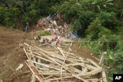 Tim penyelamat mencari korban selamat di sebuah desa yang terdampak tanah longsor di Kabupaten Tana Toraja, provinsi Sulawesi Selatan, Minggu, 14 April 2024. (Badan Pencarian dan Pertolongan Nasional via AP)