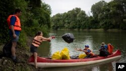 Relawan mengumpulkan sampah dari tepi sungai Tisza dekat Tiszaroff, Hungaria, Selasa, 1 Agustus 2023. (AP/Denes Erdos)