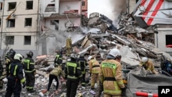 This photo released by Belgorod regional Governor Vyacheslav Gladkov on social media May 12, 2024, shows Russian emergency workers outside a partly collapsed block of flats after a Ukrainian missile attack, in Belgorod city. 