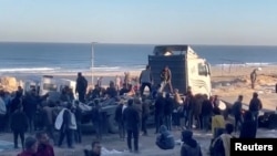 在以色列2024年2月29日据称向加沙市等待援助的人们开火后，巴勒斯坦人正在运送伤亡人员。