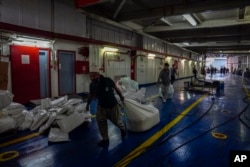 Para pekerja mempersiapkan kapal Freedom Flotilla Coalition saat berlabuh di Pelabuhan Tuzla di Istanbul, Turki, 19 April 2024. (Foto: AP)