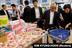 ราห์ม เอ็มมานูเอล เอกอัครราชทูตสหรัฐฯ ประจำญี่ปุ่น แวะดูลูกพีชที่ซูเปอร์มาร์เก็ต เมืองโซมะ จังหวัดฟุกุชิมา เมื่อวันที่ 31 ส.ค. 2023 [REUTES]