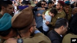 خانواده و دوستان سوگوار یاکوف الیان، یک سرباز اسرائیلی جان‌باخته، در مراسم تشییع جنازه او در قبرستانی در تل‌آویو. جمعه اول دی ۱۴۰۲ 