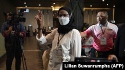 Mantan Komisioner Hak-Hak Asasi Manusia Nasional Thailand, dan juga kandidat Angkhana Neelaphaijit memberi tanda dua jari dalam putaran terkakhir pemilu senator Thailand, di Bangkok, Rabu, 26 Juni 2024. (Foto: Lilian Suwanrumpha/AFP)