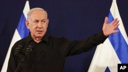 FILE - Perdana Menteri Israel Benjamin Netanyahu dalam konferensi pers dengan Menteri Pertahanan Yoav Gallant dan Menteri Kabinet Benny Gantz di pangkalan militer Kirya di Tel Aviv, Israel, 28 Oktober 2023.