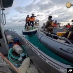 Penjaga Pantai China memegang kapak saat mendekati pasukan Filipina dalam misi pasokan di Beting Thomas Kedua di Laut Cina Selatan yang disengketakan pada 17 Juni 2024. (Angkatan Bersenjata Filipina via AP)