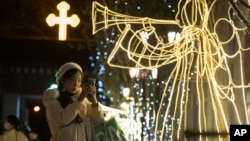 资料照片: 2023年12月25日圣诞节游客在北京西什库教堂外拍照