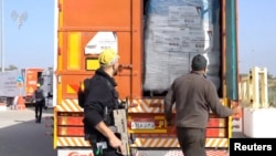 Truk yang membawa bantua untuk Gaza diperiksa ketika melintasi perlintasan Kerem shalom di perbatasan Israel, Gaza, Mesir, pada 12 Desember 2023. (Foto: COGAT via X/Handout via Reuters) 