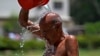 A man pours water on himself during a hot summer day at a park in Karachi, Pakistan, May 21, 2024. 