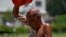 A man pours water on himself during a hot summer day at a park in Karachi, Pakistan, May 21, 2024. 