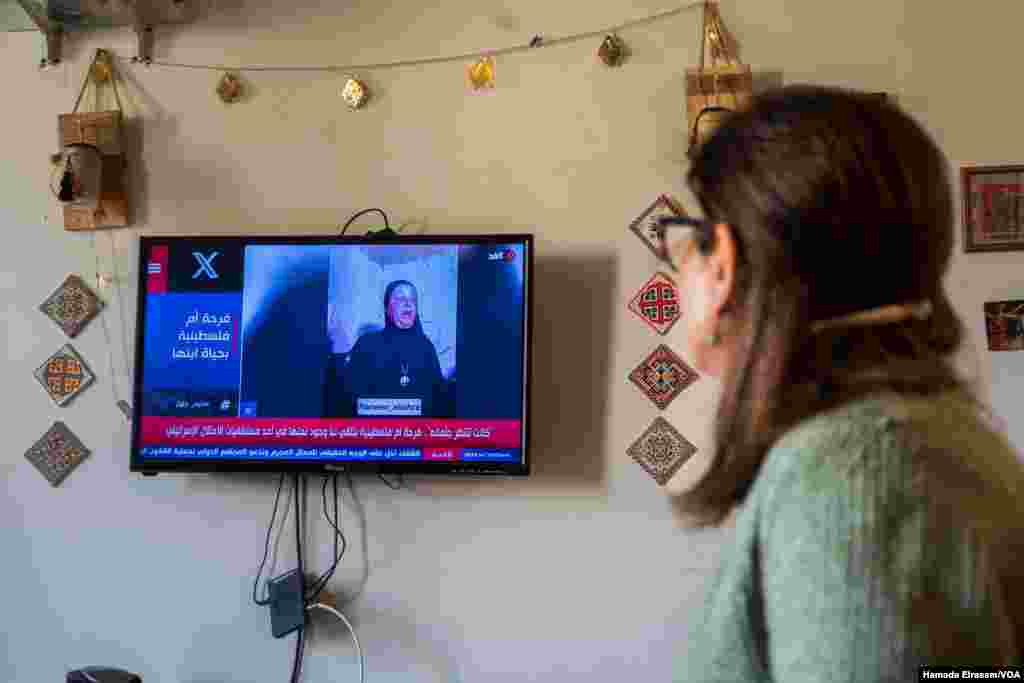 Etemad Abu Tahoun, a Palestinian mother and journalist, takes in news from Gaza, where her only son and ailing father languish. The screen reads: &ldquo;A Palestinian mother&rsquo;s happiness knowing that her son is alive.&rdquo; Cairo, Egypt, April 1, 2024.
