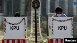 Para pemilih menggunakan hak suara mereka di TPS saat pemilihan kepala daerah di Tangerang, 9 Desember 2020. (Foto: REUTERS/Willy Kurniawan)