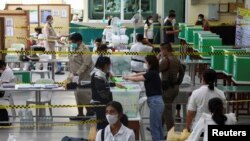 A voter casts a ballot to vote in the general election at a polling station in Bangkok, Thailand, May 14, 2023. 