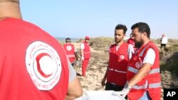FILE - Aid workers assist migrants near the Libyan-Tunisia border, July 23, 2023. 