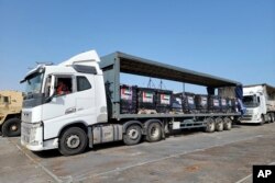 This image provided by the U.S. Army shows trucks loaded with humanitarian aid from the United Arab Emirates and the U.S. Agency for International Development cross the Trident Pier before arriving on the beach on the Gaza Strip, May 17, 2024.