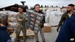 Menteri Luar Negeri AS Antony Blinken (tengah) ikut membantu personel militer AS membawa bantuan bagi korban gempa, di Pangkalan Udara Incirlik dekat Adana, Turki, Minggu 19 Februari 2023. 