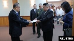 지난해 7월 북한 조선중앙통신이 공개한 중국 공산당 정치국 위원 리홍중이 시진핑 중국 국가주석의 친서를 김정은 북한 국무위원장에 전달하는 모습.