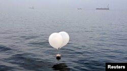 A balloon carrying various objects including what appeared to be trash, believed to have been sent by North Korea, is pictured at the sea off Incheon, South Korea, June 9, 2024. 