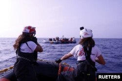 Boti ya uokoaji ya Medicins Sans Frontiers (MSF) ikiwa karibu na boti ya mpira iliyobeba wahamiaji kutoka Mashariki ya Kati na Afrika, Juni 24, 2023. MSF/Skye McKee/Handout via REUTERS