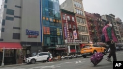 A six story glass facade building, second from left, is believed to be the site of a foreign police outpost for China in New York's Chinatown, Monday April 17, 2023. (AP Photo/Bebeto Matthews)