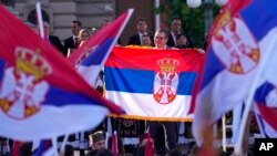 Predsjednik Srbije Aleksandar Vučić pokazuje drži zastavu Srbije na skupu "Svesrpski sabor" u Beogradu, Srbija, u subotu, 8. juna 2024.