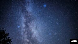 FILE - A picture taken in Fontainebleau, southern Paris on August 13, 2023 shows shooting stars streaking across the Milky Way during the "Nuits des étoiles" (Starry Night), a major annual celebration for astronomy enthusiasts. (Photo by Miguel MEDINA / AFP)