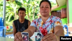 The parents of Natthaporn, who was working in Israel and has been abducted in the ongoing conflict between Israel and the Palestinian Islamist group Hamas, hold up his pictures at their house in Nakhon Phanom, Thailand, Oct. 10, 2023. 
