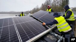 FILE - Solar panels are installed on a lake in Haltern, Germany, Friday, April 1, 2022. (AP Photo/Martin Meissner, File)