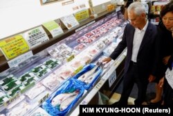Duta Besar AS untuk Jepang Rahm Emanuel melihat ikan hasil tangkapan lokal di Pasar Ikan Hamanoeki selama kunjungannya untuk menunjukkan dukungannya terhadap pembuangan air dari PLTN Fukushima, Jepang, 31 Agustus 2023 .(Foto: REUTERS/Kim Kyung-Hoon)