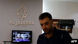 FILE - An employee of Qatar-based news channel Al Jazeera is seen at the media outlet's offices in Jerusalem, July 31, 2017.