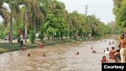 Residents of Lahore take a dip in a canal to cool off as temperatures rise, May 22, 2024. (Photo: Shahzad Gul)