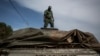 FILE - A member of the Mozambican Forestry Police stands on the top of truck suspected of carrying illegal wood, in Pemba, Cabo Delgado province, Mozambique, Feb. 13, 2017.