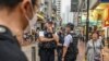 Polisi berpatroli di jalan-jalan di distrik Causeway Bay, Hong Kong, 3 Juni 2024, dekat Taman Victoria, tempat orang-orang biasanya berkumpul setiap tahun pada tanggal 4 Juni untuk berduka atas para korban penumpasan Lapangan Tiananmen di China tahun 1989. (Peter PARKS / AFP)