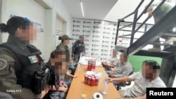 Polisi Meksiko bersama dengan para migran yang berhasil diselamatkan dari sebuah peternakan, bagian dari kelompok sekitar 50 orang yang diculik dari sebuah bus di negara bagian Nuevo Leon timur laut, di fasilitas Kantor Kejaksaan Agung di San Luis Potosi, Meksiko 18 Mei 2023.