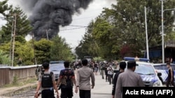 Polisi berupaya membubarkan kerumunan masa di Wamena, Papua, 23 Februari 2023. Polisi memperketat keamanan di kota Wamena, wilayah timur Papua, setelah 10 orang tewas dalam kerusuhan yang dipicu oleh desas-desus penculikan anak.(ACIZ RAZI / AFP)