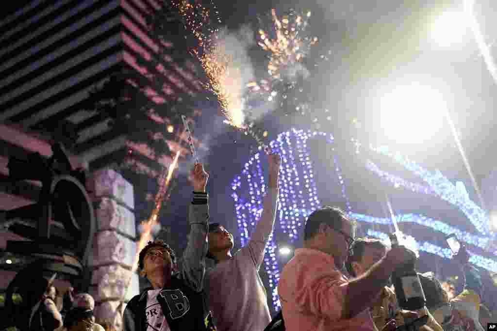 People celebrate the start of the New Year as fireworks illuminate Copacabana Beach in Rio de Janeiro, Brazil, Jan. 1, 2024.