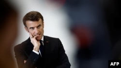 FILE - French President Emmanuel Macron gestures as he speaks with schoolchildren of the Jean Lartaut Middle School in Jarnac, western France, Feb. 28, 2023.
