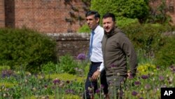 Britain's Prime Minister Rishi Sunak, left, and Ukraine's President Volodymyr Zelenskyy, walk in the garden at Chequers, the prime minister's official country residence, in Aylesbury, England, May 15, 2023.