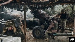 Ukrainian soldiers fire a cannon near Maryinka, an eastern city where fierce battles against Russian forces have been taking place, in Ukraine's Donetsk region, May 8, 2023.