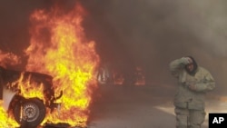 A truck burns after it was set fire by rural teachers' college students, as firefighters work to control the blazes outside the municipal government palace in Chilpancingo, Mexico, April 8, 2024. 