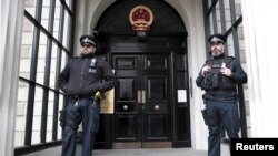 FILE - Policemen stand guard outside China's Embassy in London, Britain, Oct. 18, 2015. A statement issued Sunday by the diplomatic mission called a visit by British lawmakers, planned for Monday, a "gross interference in China's internal affairs."