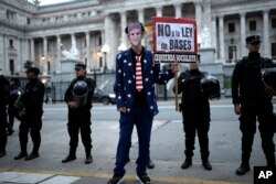 Seorang pengunjuk rasa mengenakan topeng Presiden Argentina Javier Milei saat berlangsungnya aksi unjuk rasa anti-pemerintah di luar gedung Kongres di Buenos Aires, Argentina, Senin, 29 April 2024 . (AP/Rodrigo Abd)