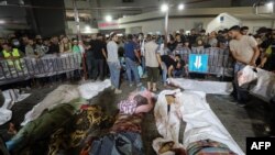 Une foule rassemblée autour des corps des personnes décédées dans l'attaque contre l'hôpital central de Gaza, le 17 octobre 2023.