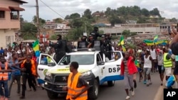 FILE - This image taken from video shows coup supporters cheering police officers in Libreville, Gabon, on Aug. 30, 2023.
